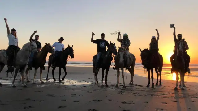 Ballade à cheval sur la plage au coucher du soleil